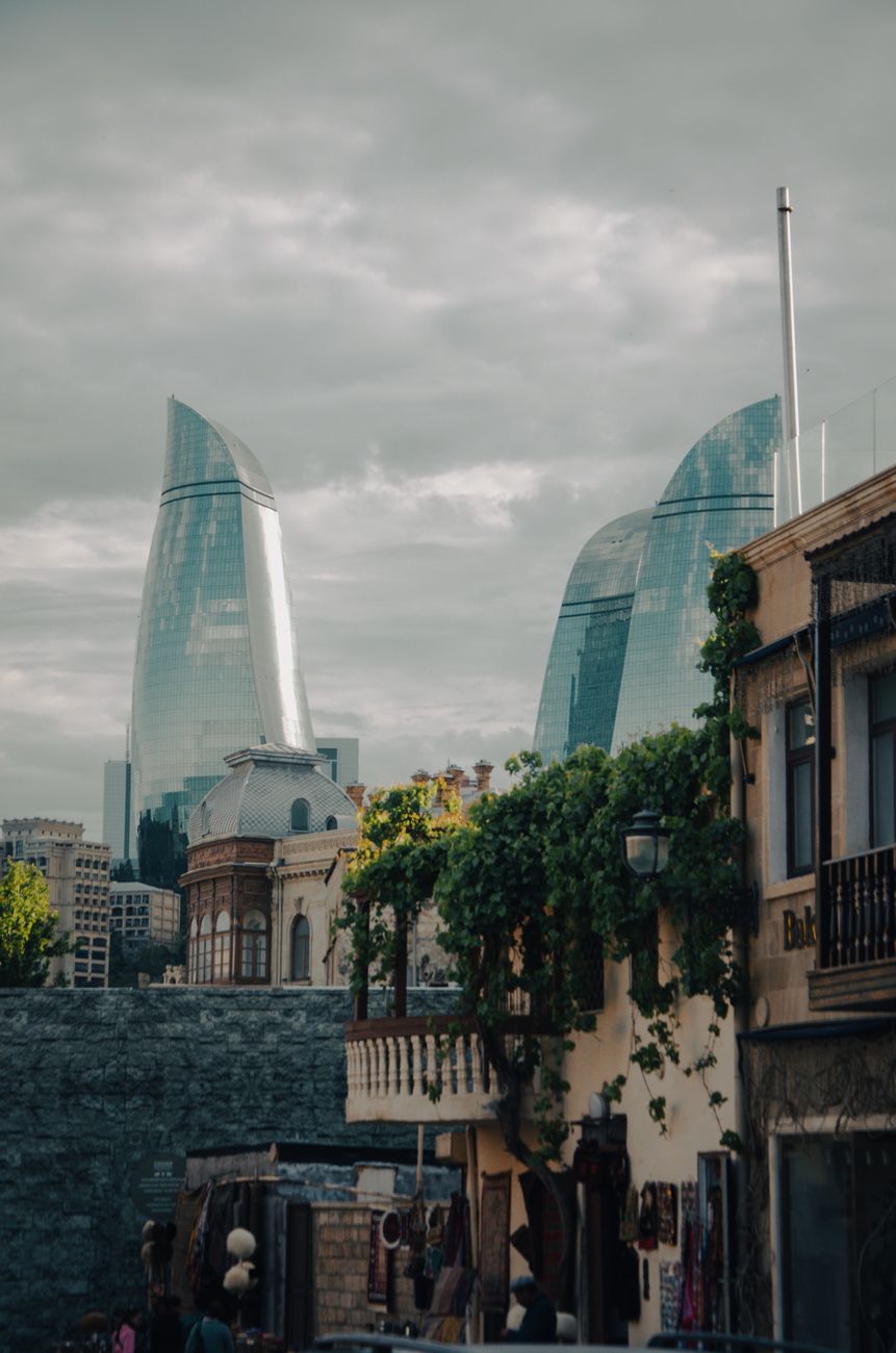 traditional street in baku city and modern flame towers in the distance